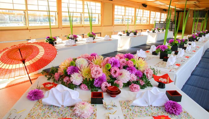 新郎新婦の後ろに金屏風が立て掛けられている一松の会場